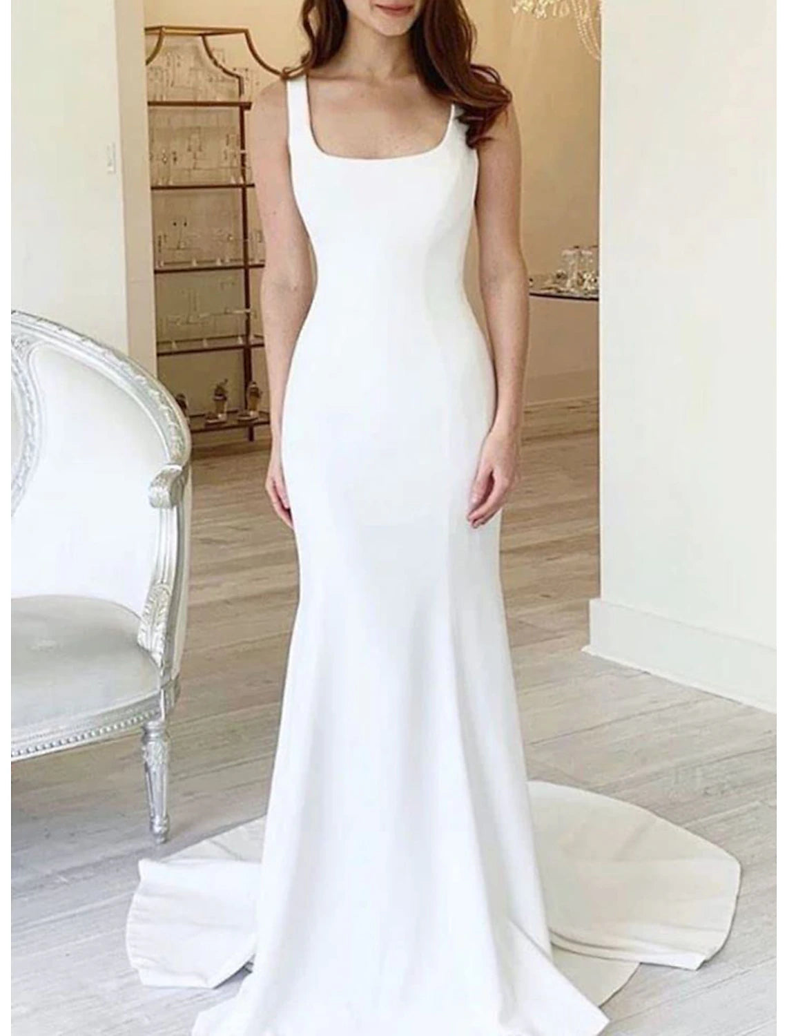 Back view of the sleeveless mermaid bridal gown with a flowing court train.