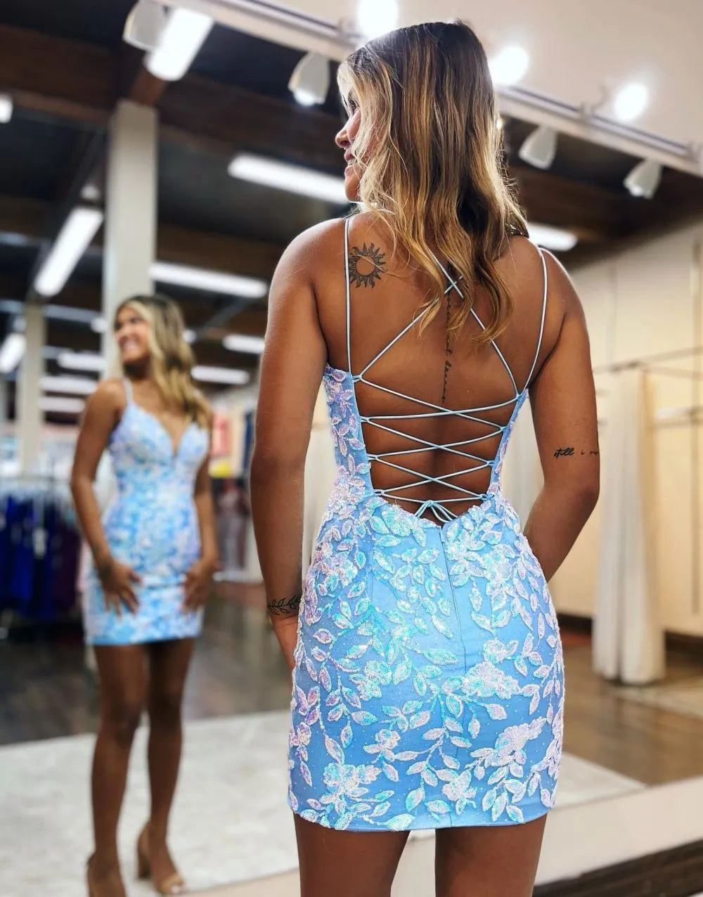 Full view of a bodycon spaghetti strap dress adorned with appliques.