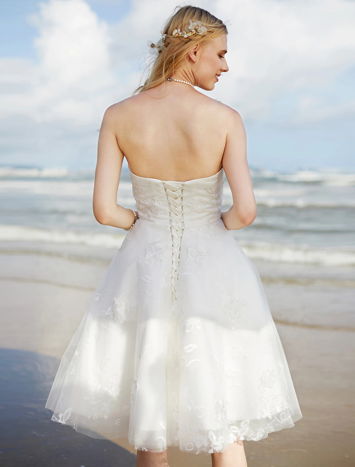 Side view of a boho A-line sweetheart strapless lace wedding dress.