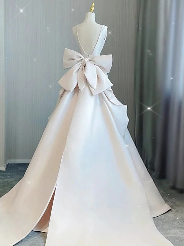 Side view of the elegant A-line satin wedding dress with a flowing court train.