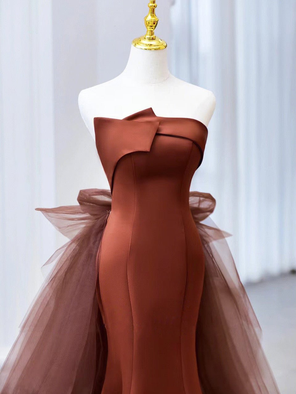 Back view of a mermaid trumpet prom dress with flowing tulle.