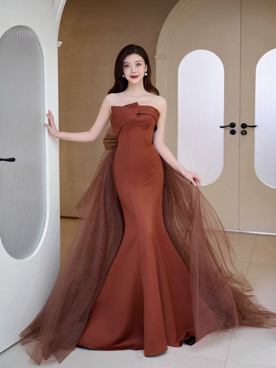 Model posing in a chic strapless trumpet prom gown.