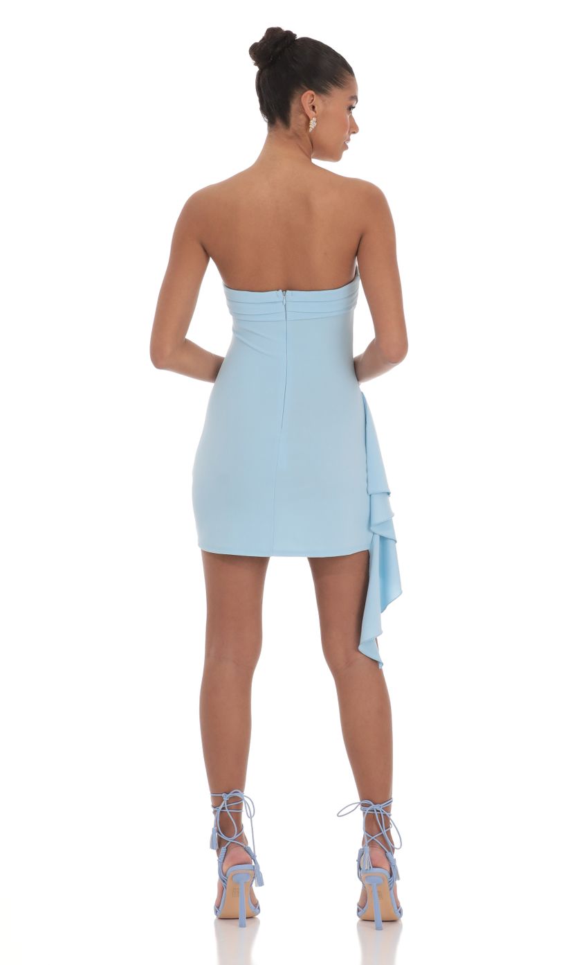 Side view of the strapless ruched asymmetrical short dress on a model.
