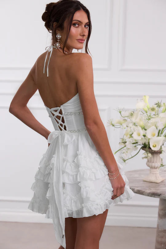 Side profile of a short blue A-line dress with a halter neckline.