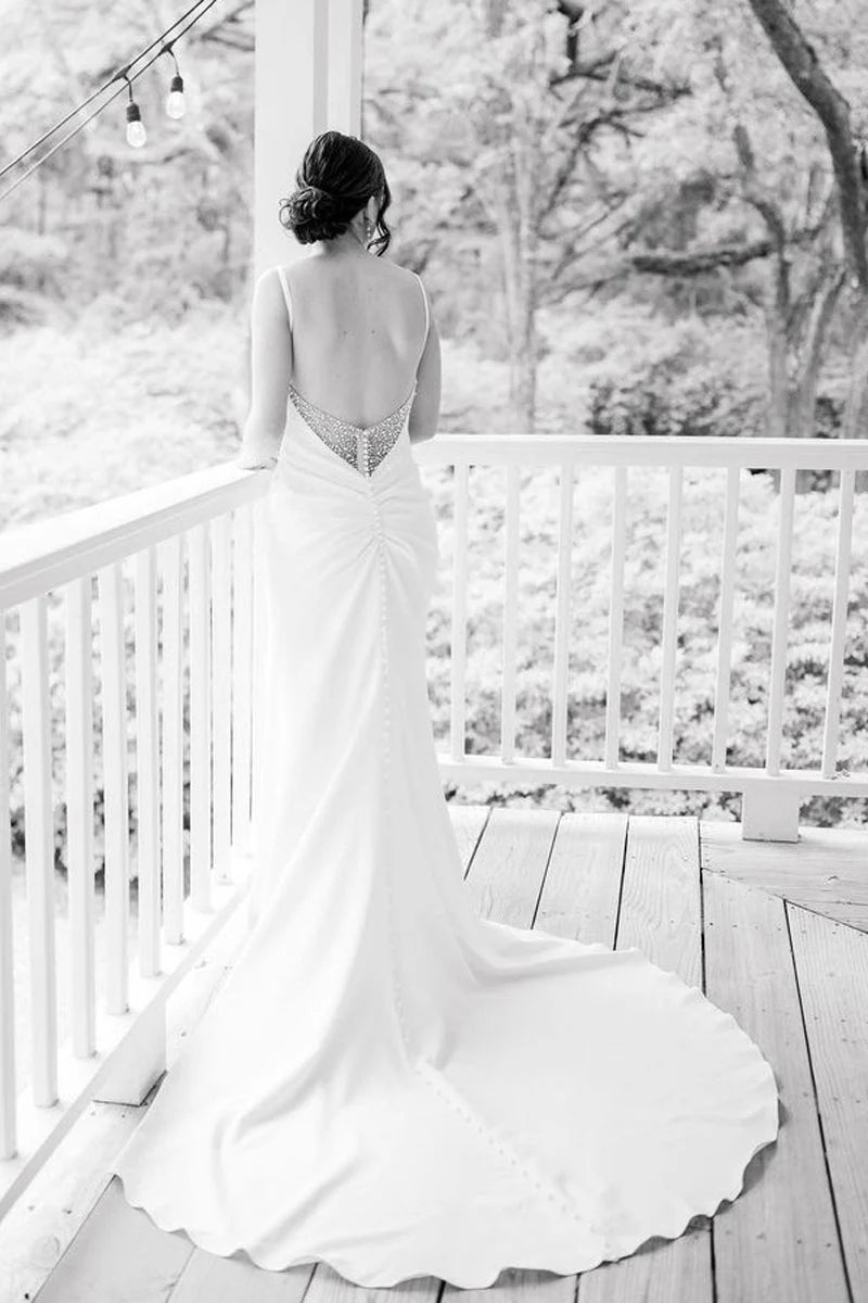 Mermaid satin wedding dress showing the high leg slit and flowing train.
