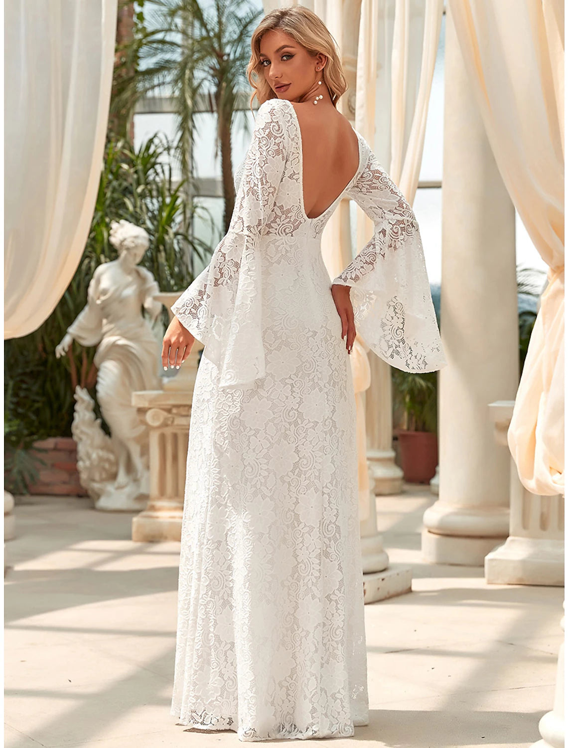 Side profile of the floor-length lace wedding dress with a graceful train.