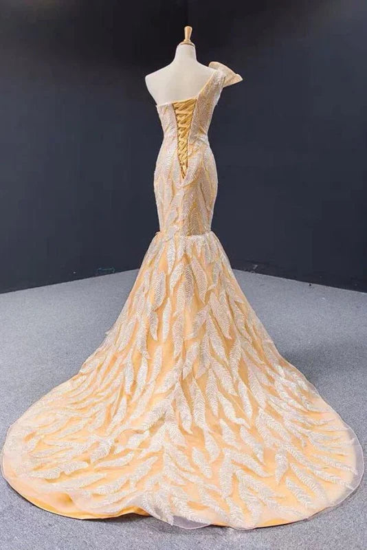 Woman posing in a chic one-shoulder mermaid long prom dress.