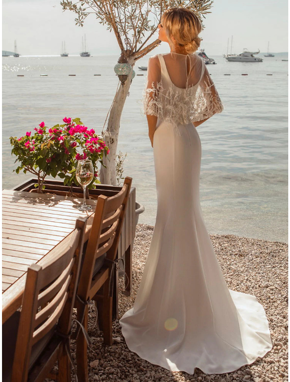 Back view of a mermaid satin wedding dress showing button details and an open back.