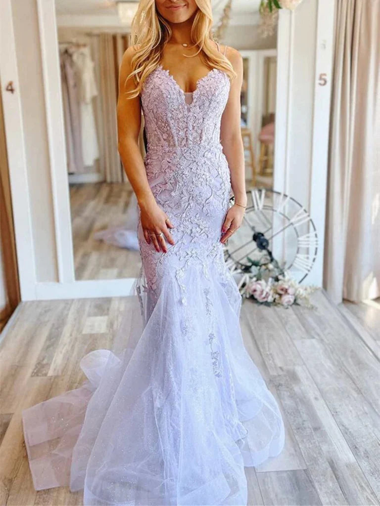 Woman wearing a dark blue mermaid V-neck lace floral long prom dress.