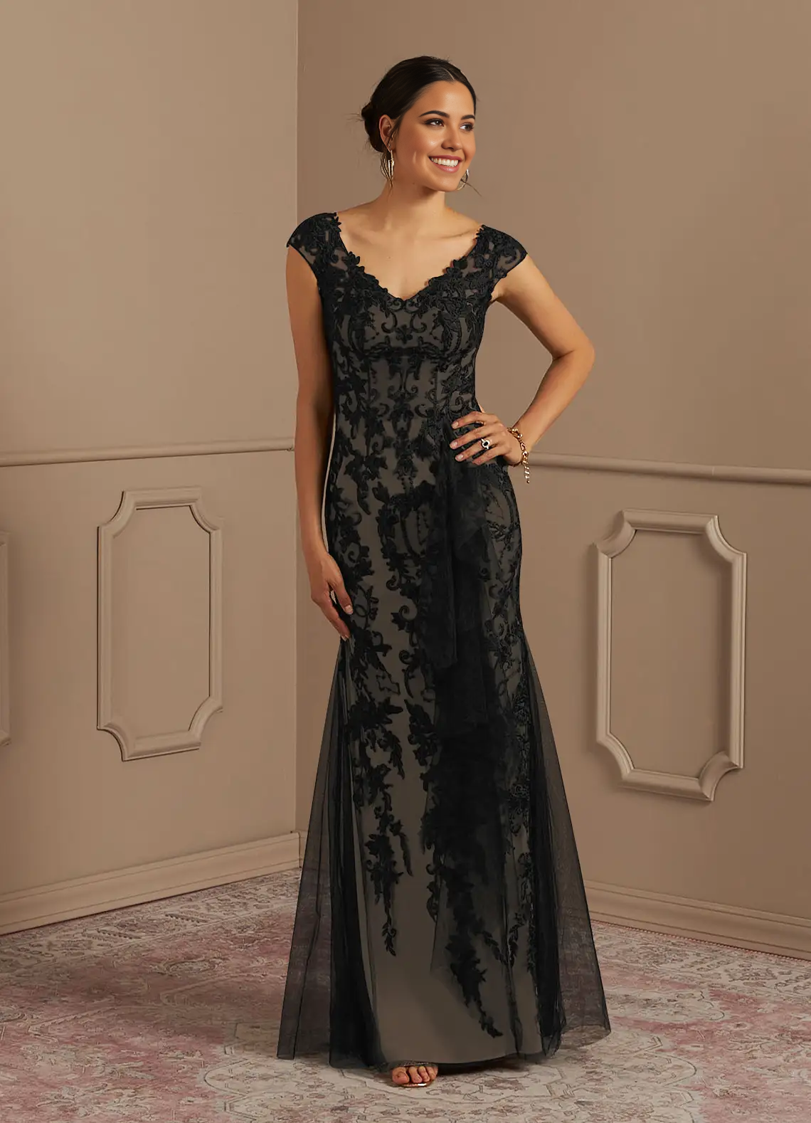 A woman wearing a black and champagne mermaid lace tulle formal dress.
