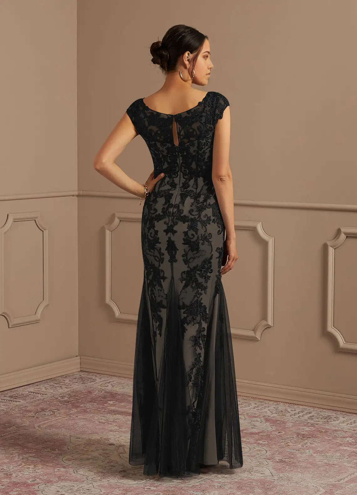 Full view of the elegant black and champagne mermaid gown with lace details.