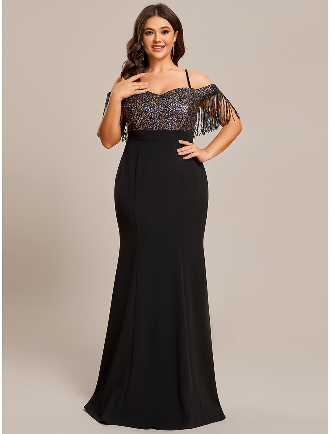 Woman wearing an elegant off-shoulder mermaid gown with fringe tassels.