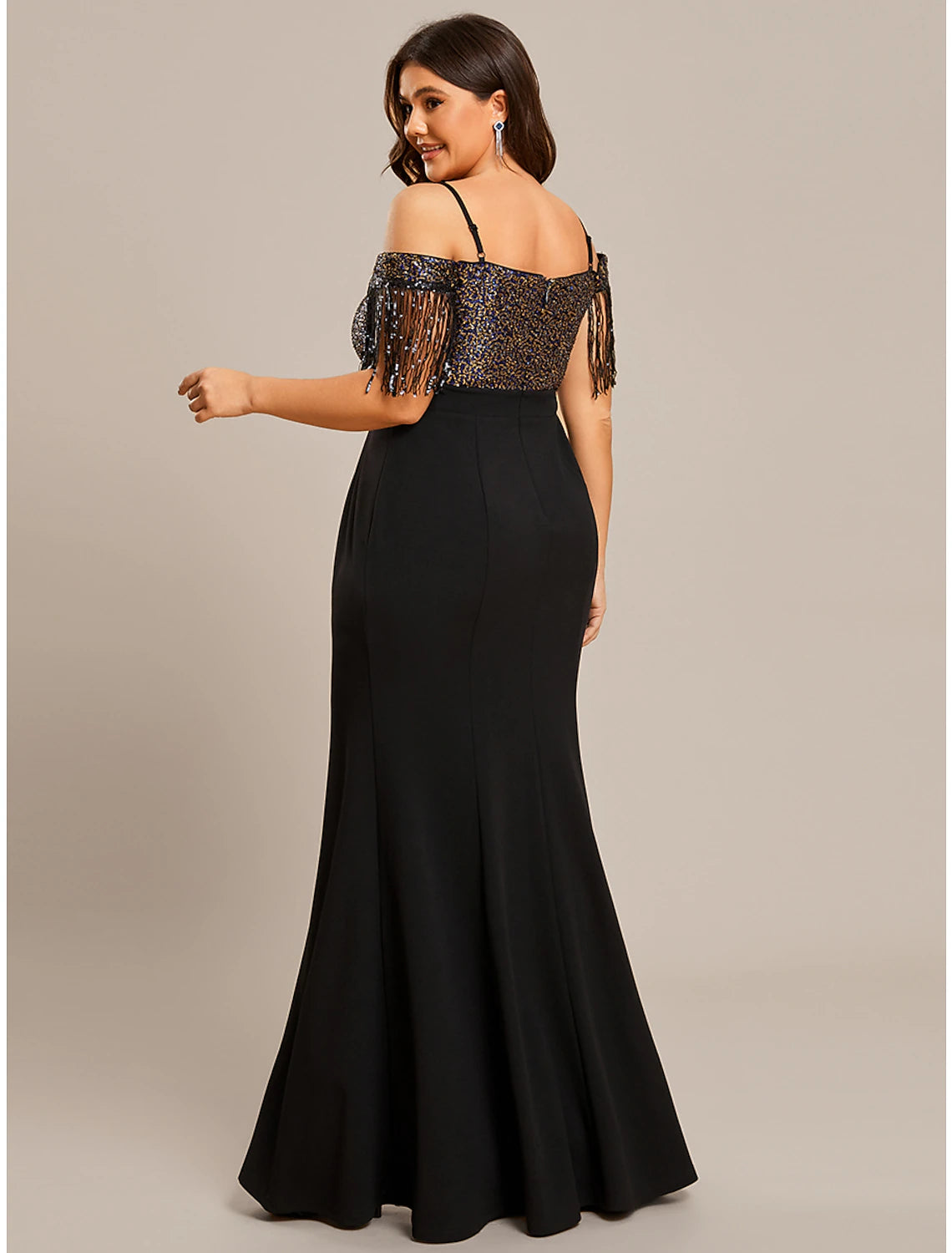 Woman posing gracefully in a floor-length off-shoulder mermaid dress.