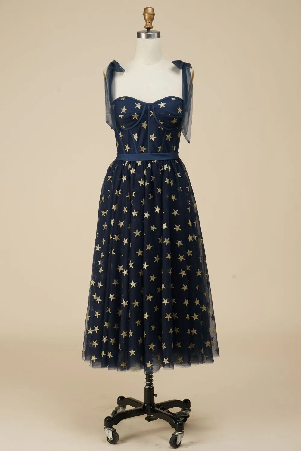 Navy A-line tea length dress with star pattern, front view.