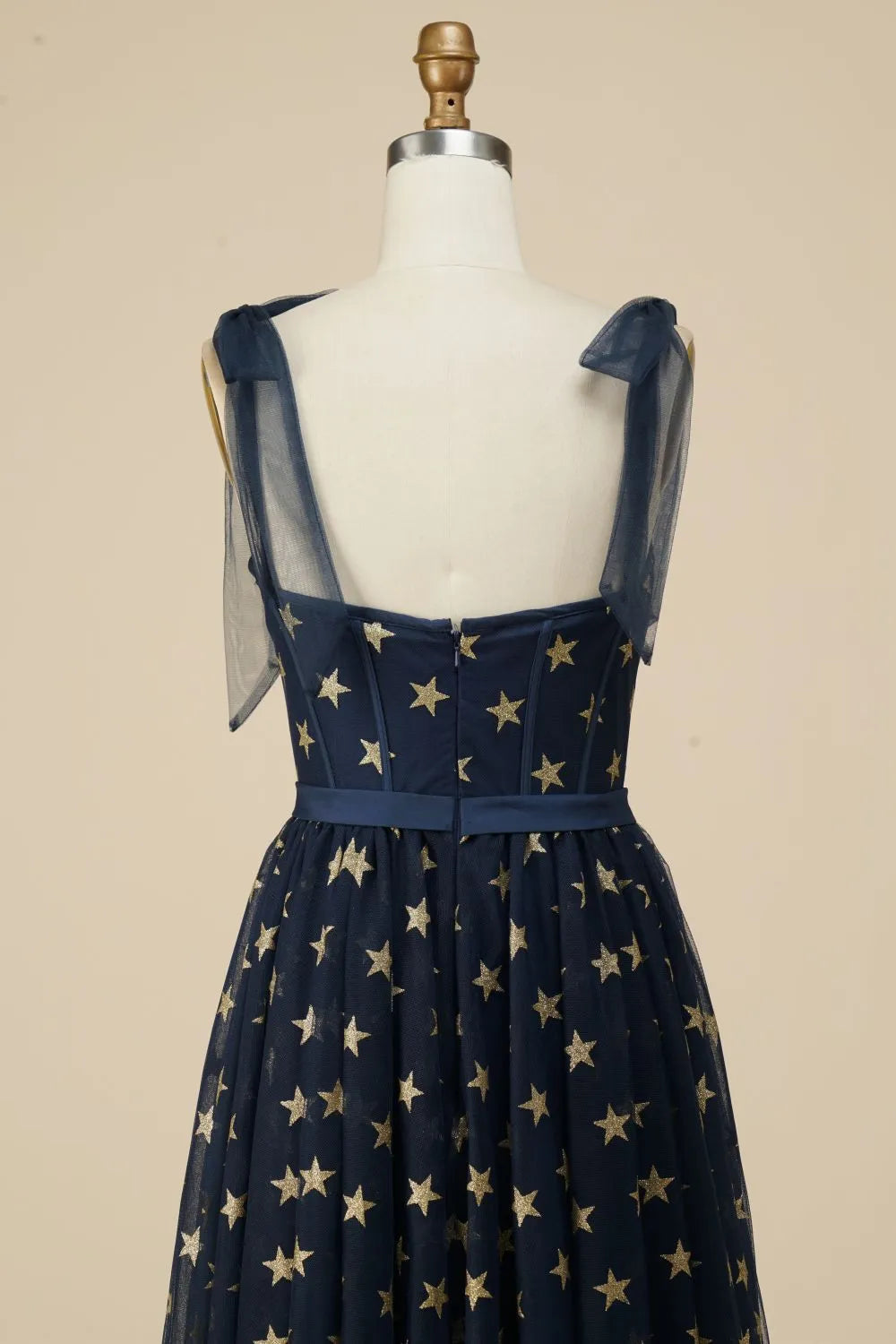 Close-up of star pattern on navy tea length dress fabric.