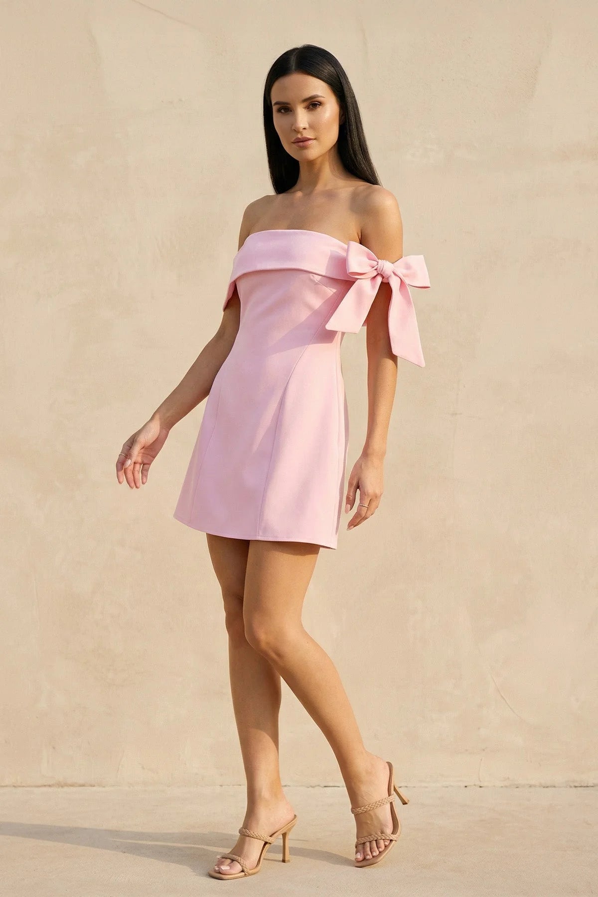 Close-up of the off-shoulder neckline and statement bow on the mini dress.