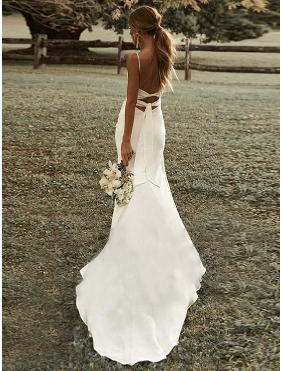 Modern bridal gown featuring stretch fabric and a sweep train.