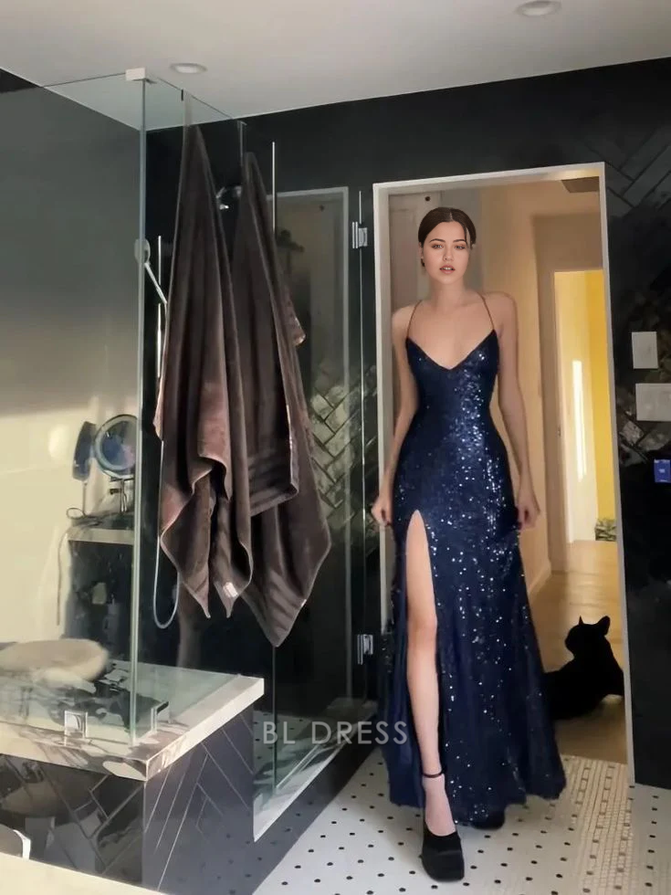 Woman wearing a navy blue sheath V-neck dress with a high slit, full length view.