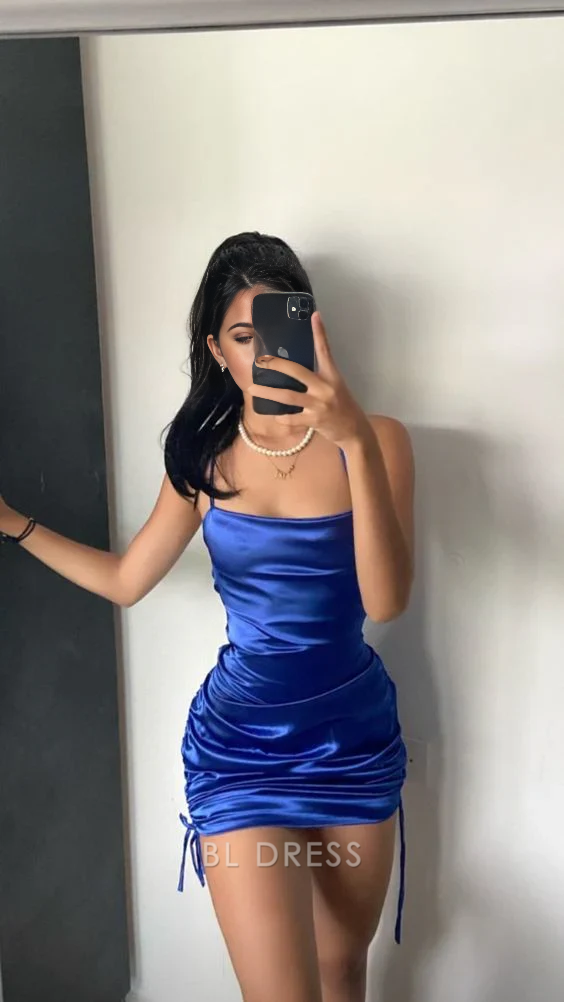 Woman wearing a blue short sheath dress with spaghetti straps and V-neck.