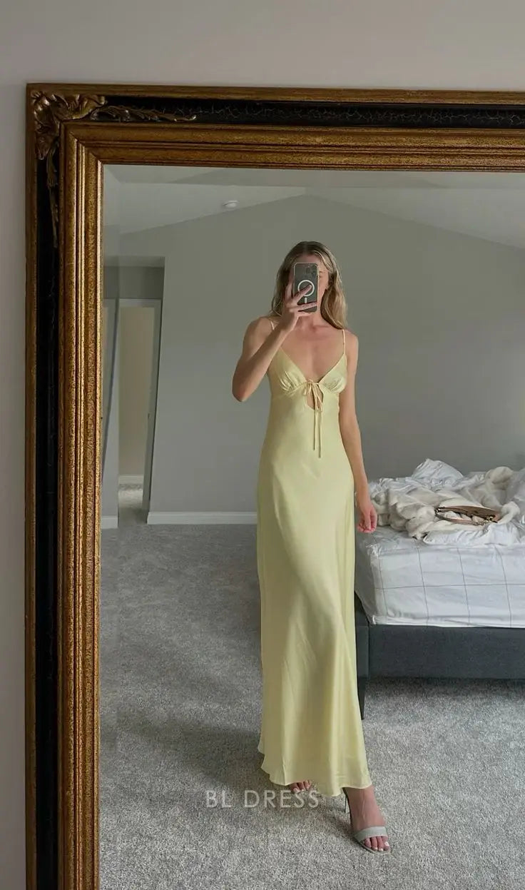 Woman wearing a long yellow sheath dress with spaghetti straps and V-neck.