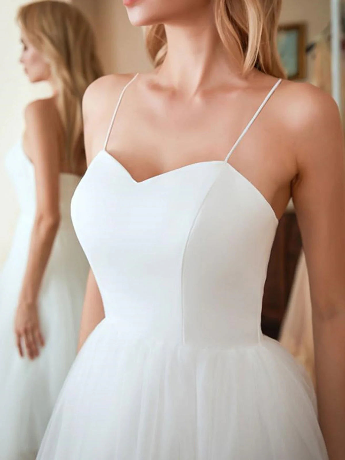 Close-up of the sweetheart neckline and tulle fabric on a wedding dress.