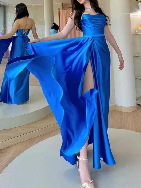 Woman wearing a chic open back long prom dress with a high slit.