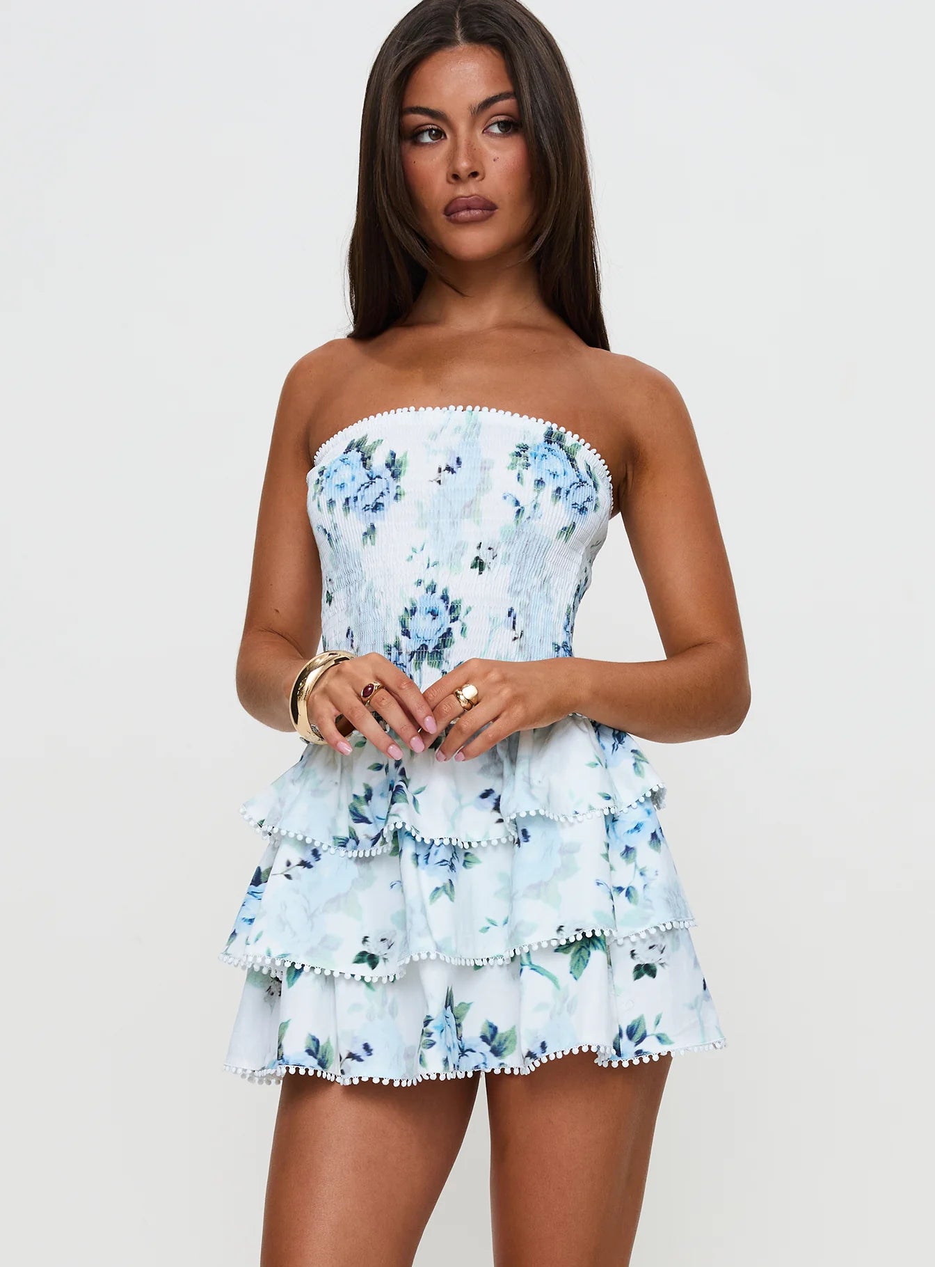 Close-up of the smocked bodice and floral print on a white and blue mini dress.