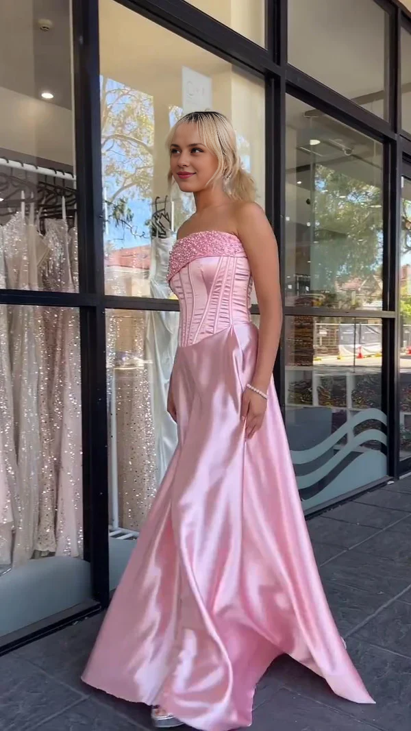 Woman wearing a chic strapless sweetheart A-line satin long prom dress.