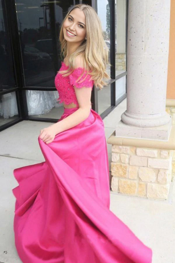 Back view of a model in a fuchsia two-piece off-shoulder prom dress.