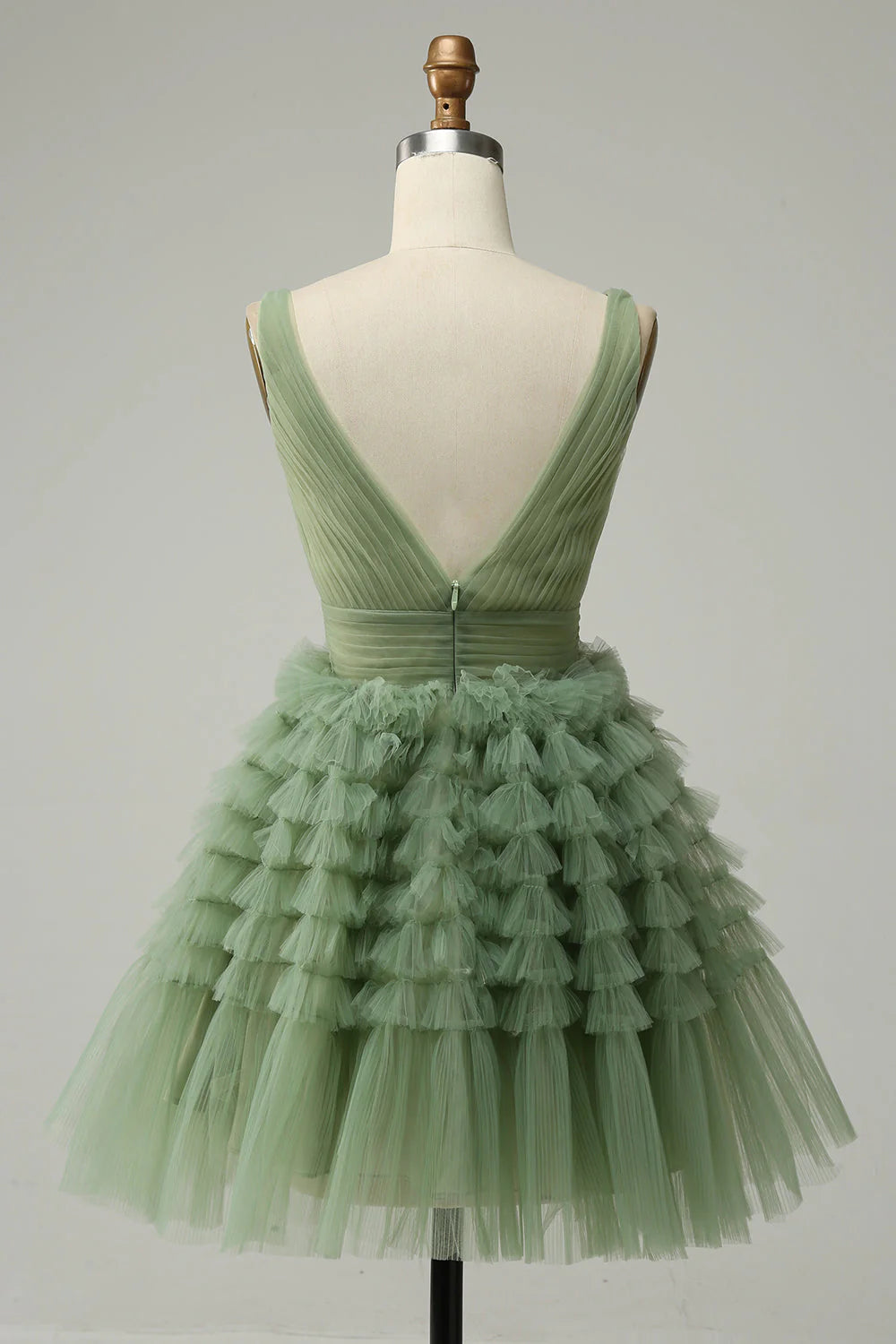 Back view of green tulle prom dress, highlighting open back.