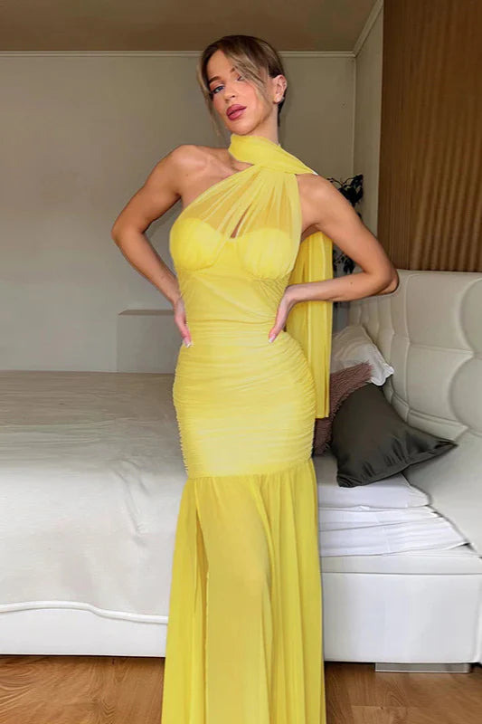 Woman wearing a yellow halter keyhole ruched maxi dress.