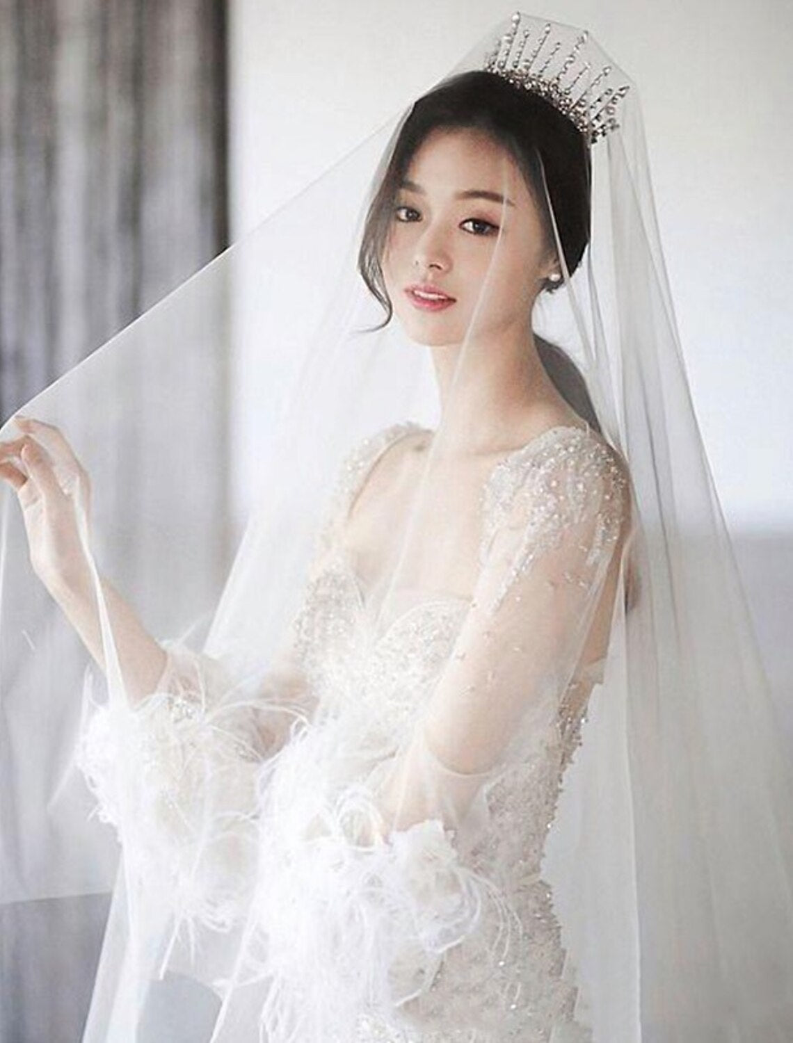 Bride wearing a classic one-tier cathedral wedding veil made of pure tulle, viewed from behind.
