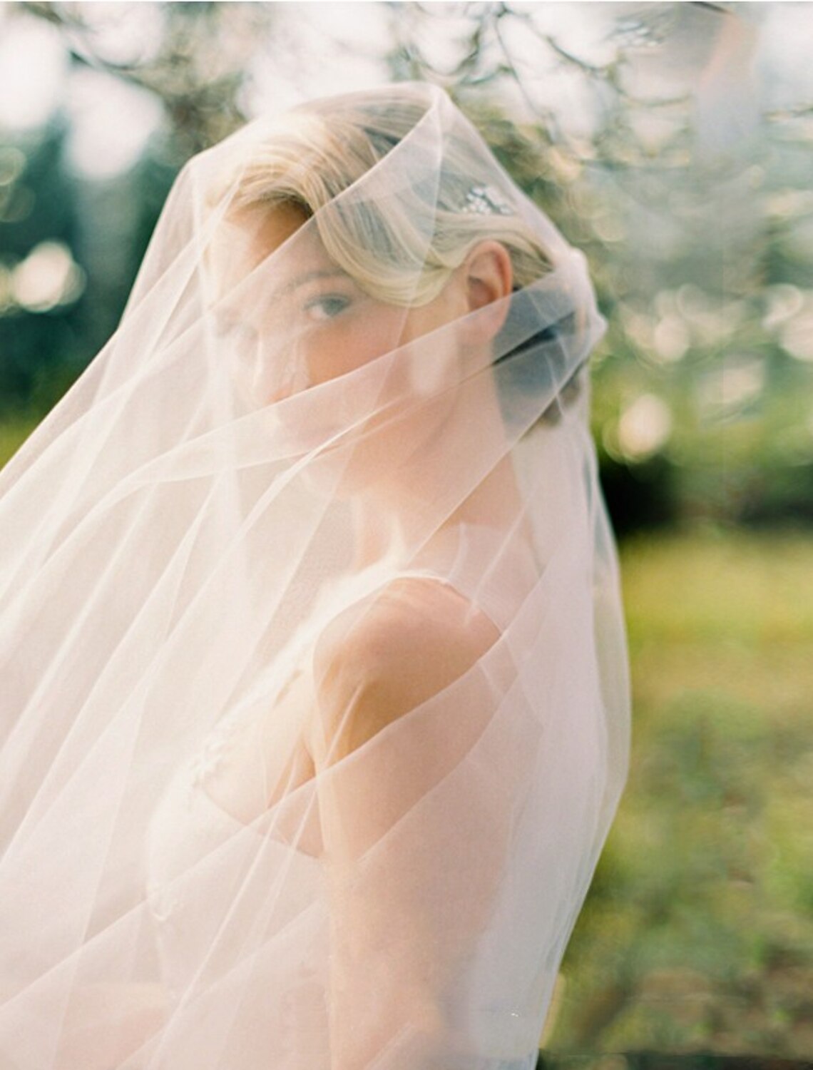 Side view of a bride wearing an elegant one-tier tulle cathedral veil.
