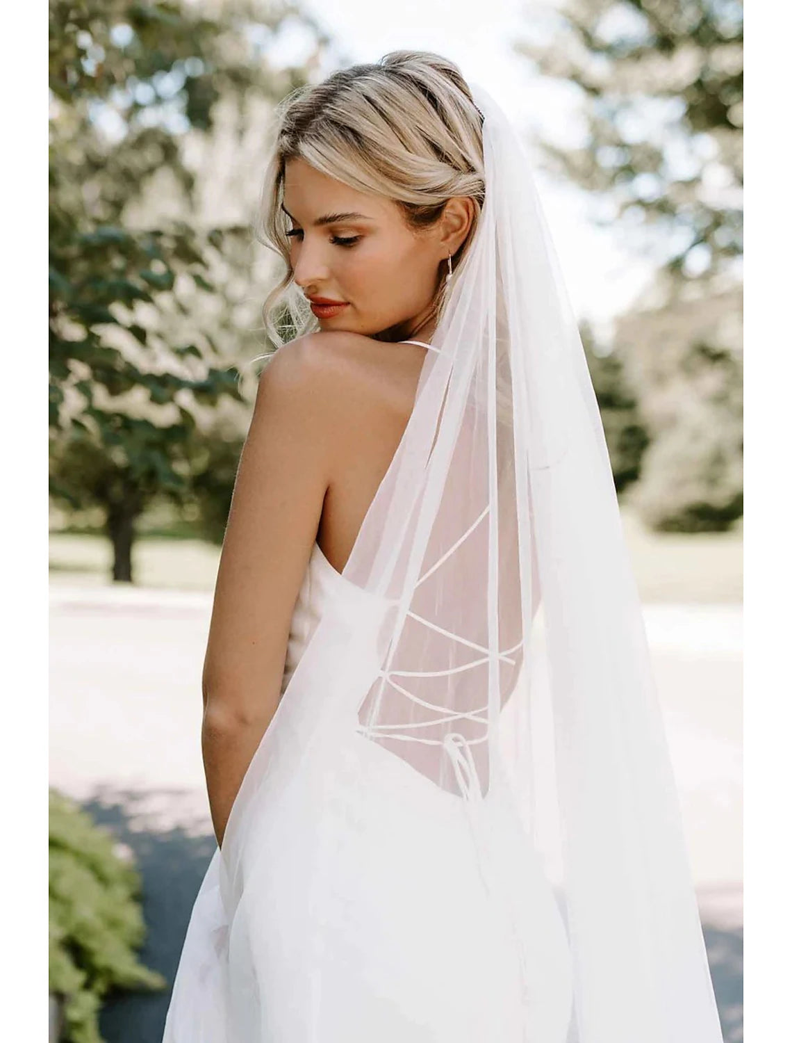 Side profile of a bride wearing the sheer tulle wedding veil.