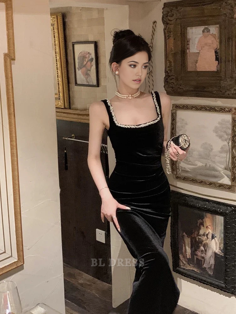 Model wearing a black velvet sheath V-neck long formal dress with thin straps.