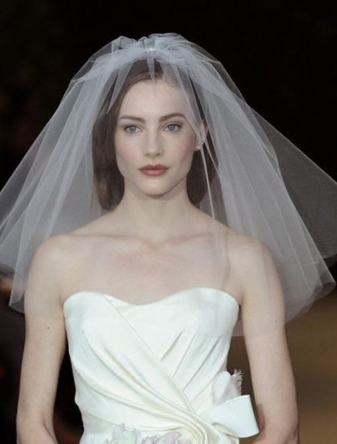Bride wearing a classic two-tier shoulder length wedding veil from behind.