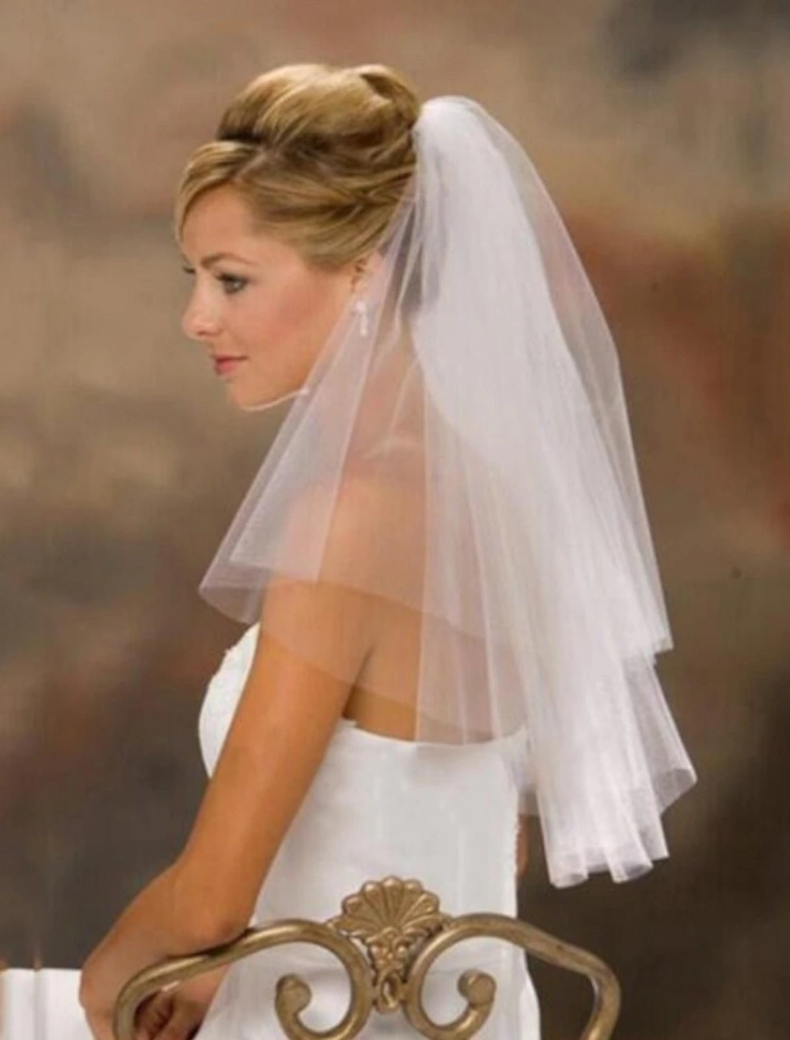 Side view of a bride wearing a pure color tulle wedding veil.