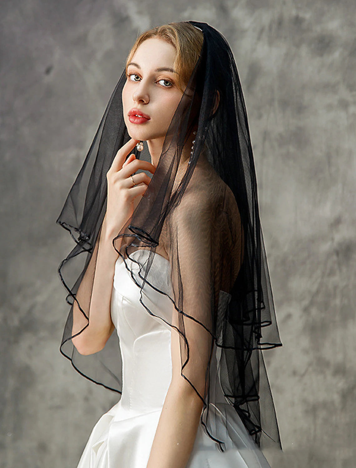 Elegant two-tier elbow wedding veil with a delicate flower comb draped.