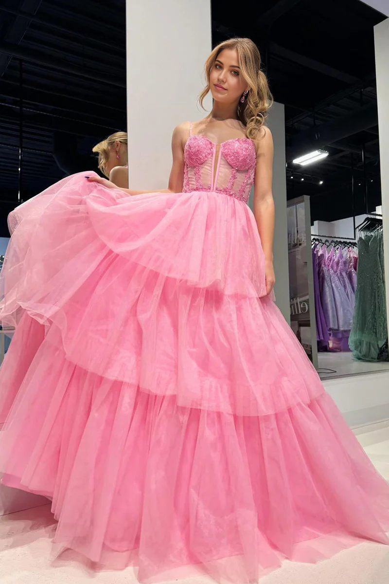 Model wearing a pink A-line tiered tulle prom dress with sweetheart neckline.