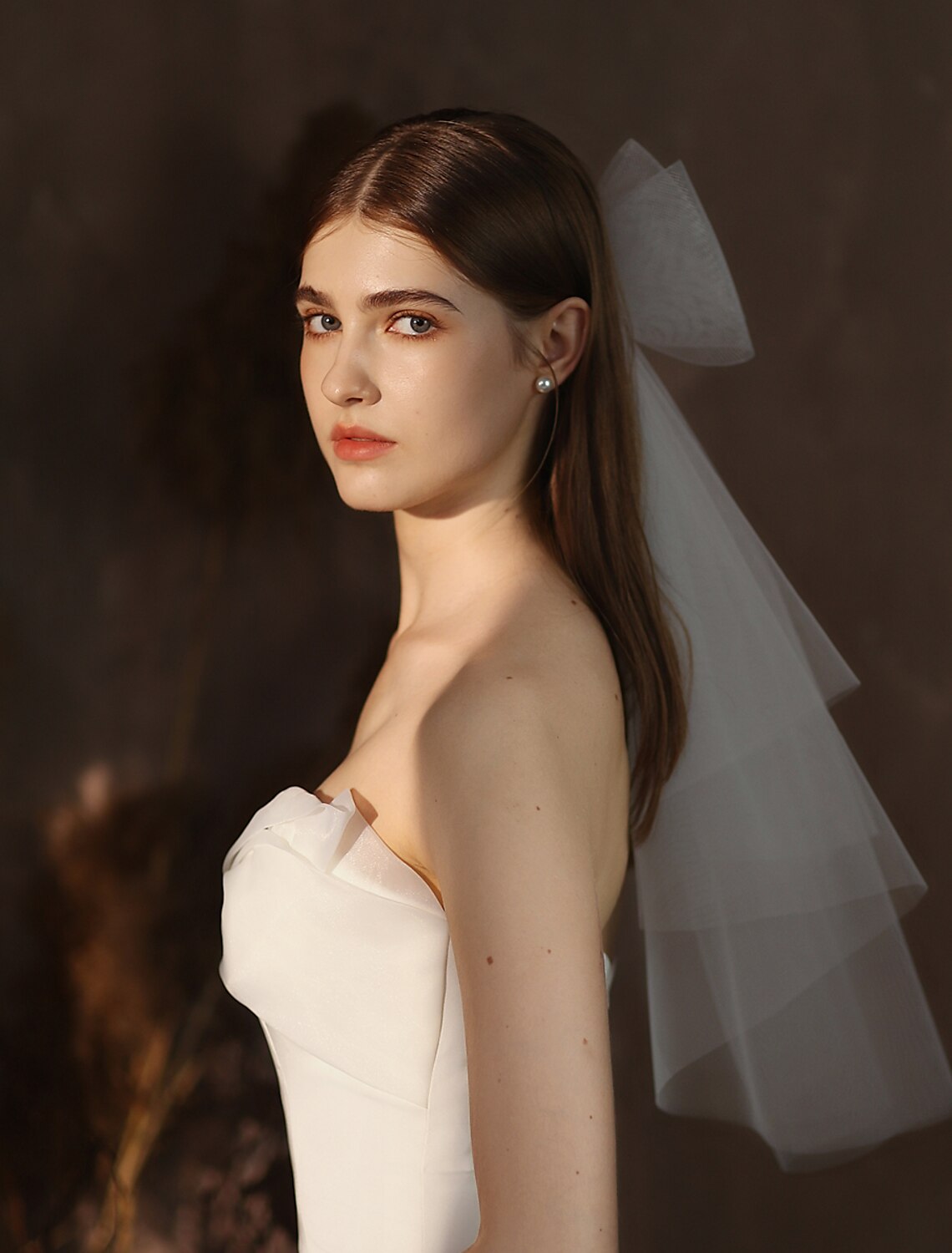 Bride wearing a two-tier elbow length tulle wedding veil.