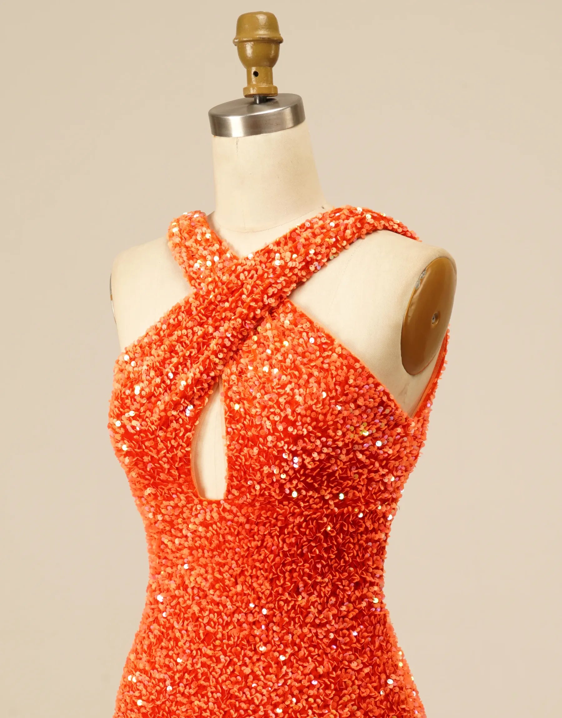 Close-up of sequin embellishments on the halter mini dress fabric.