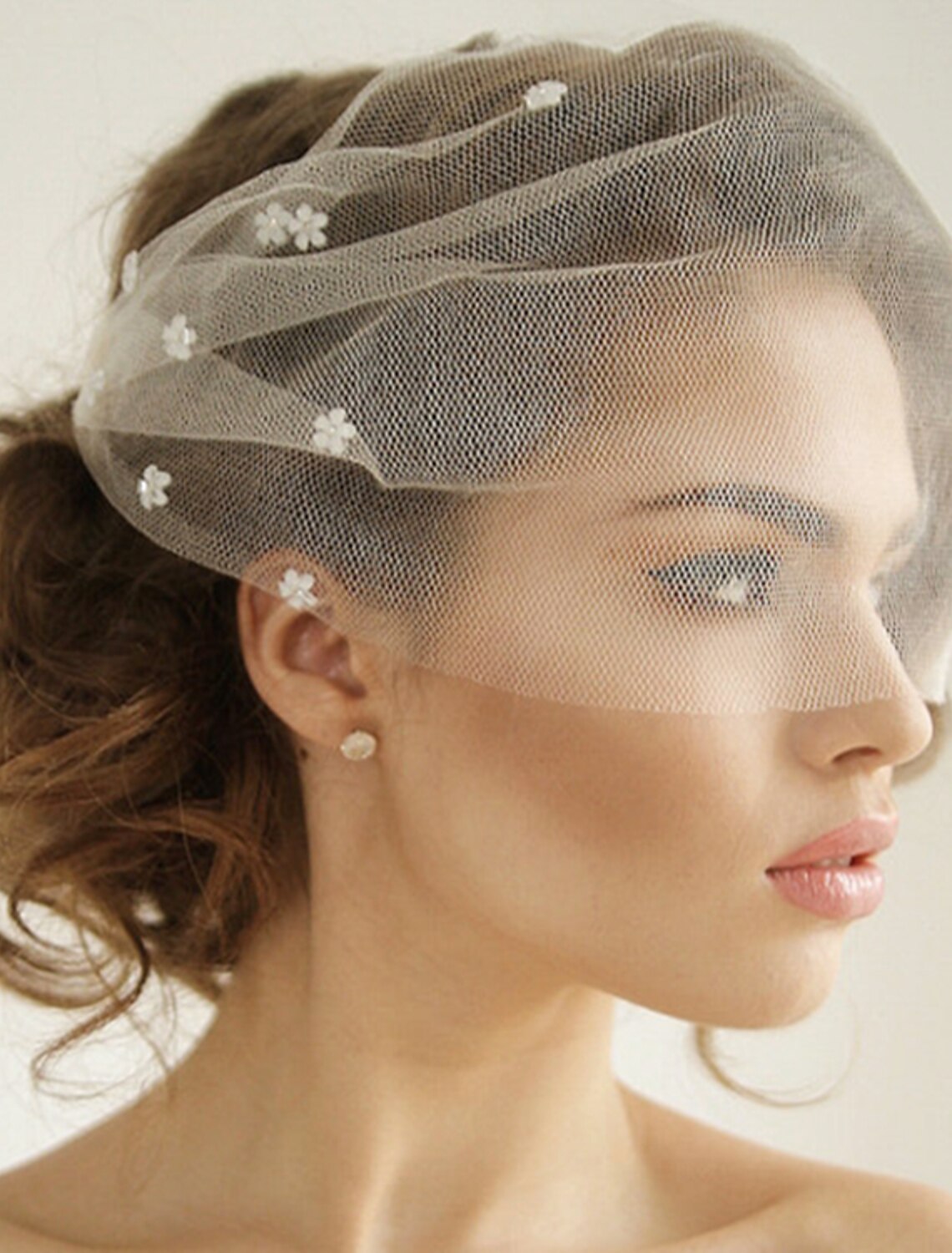 Bridal model wearing a one-tier blusher wedding veil adorned with rhinestones and tulle.