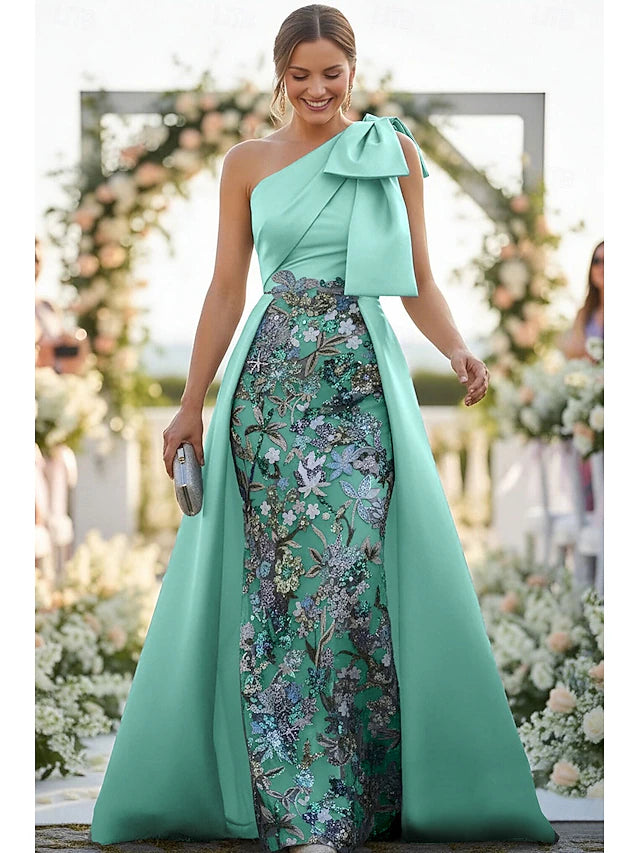Model wearing a dazzling emerald green sequin gown with a plunge V-neck and high slit.