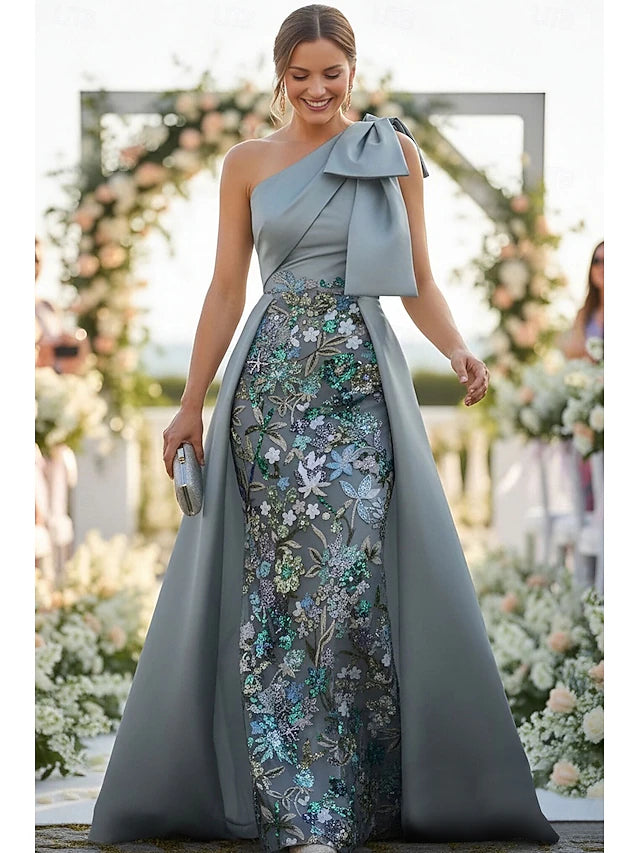Full view of a shimmering emerald green sequin gown with spaghetti straps.