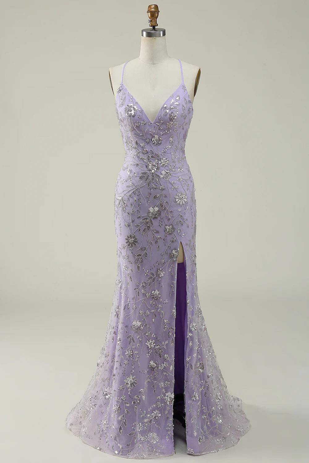 Woman wearing a dazzling purple sequin mermaid prom dress with a V-neck and high slit.