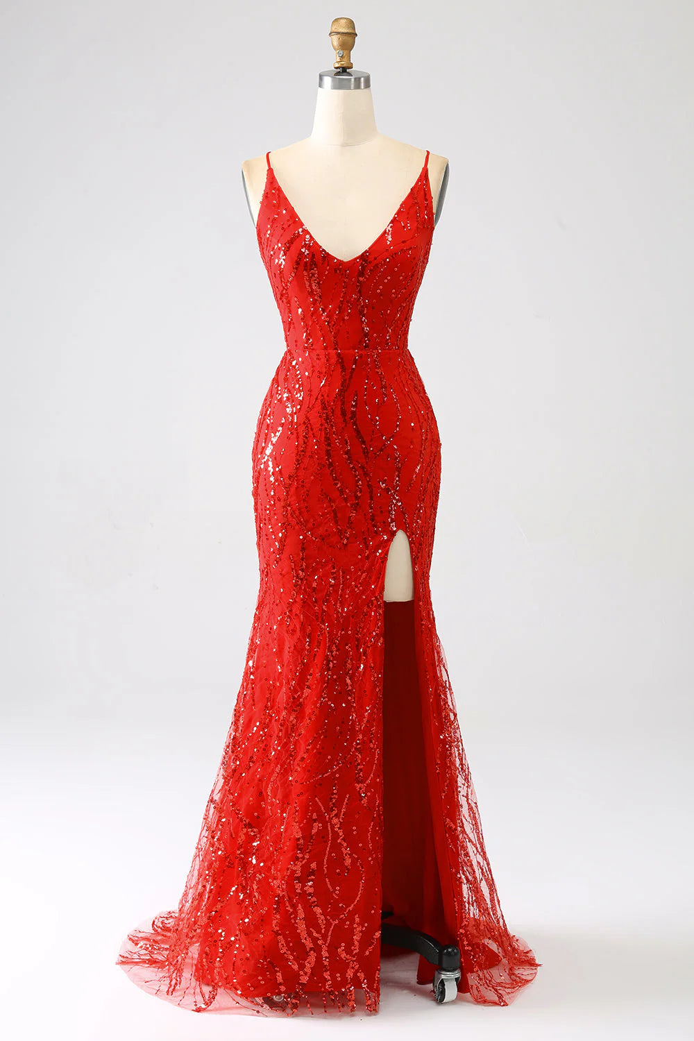 Front view of a woman wearing a dazzling red sequined mermaid prom gown with a high slit.