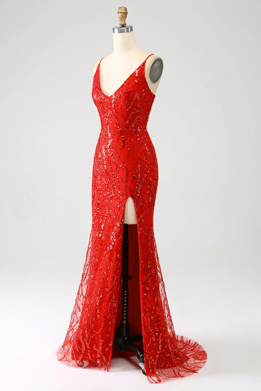 Side view of a woman posing in a red sequined mermaid evening gown with a thigh-high slit.