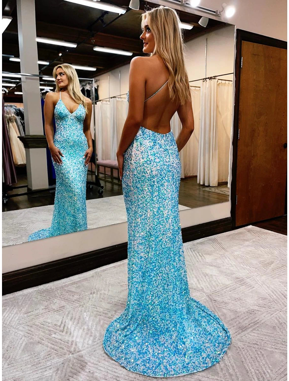 Back view of a sequined mermaid prom dress featuring an open back.