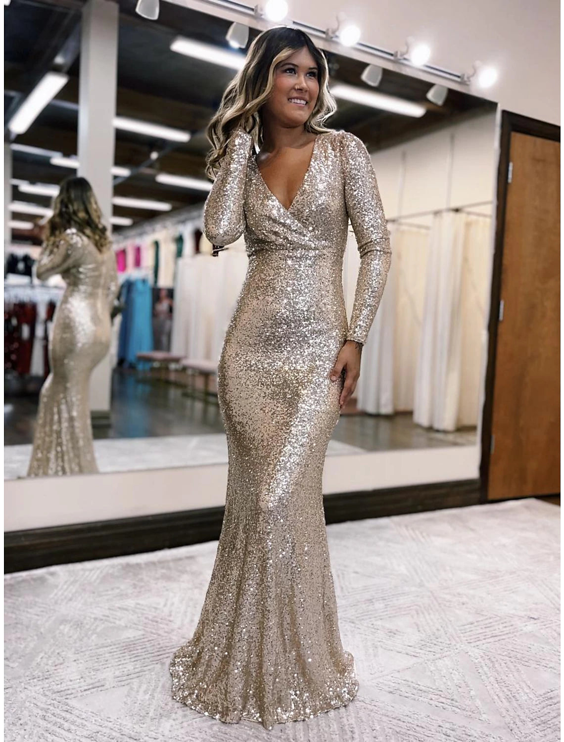 Model wearing a dazzling sequined Mermaid Trumpet evening gown.
