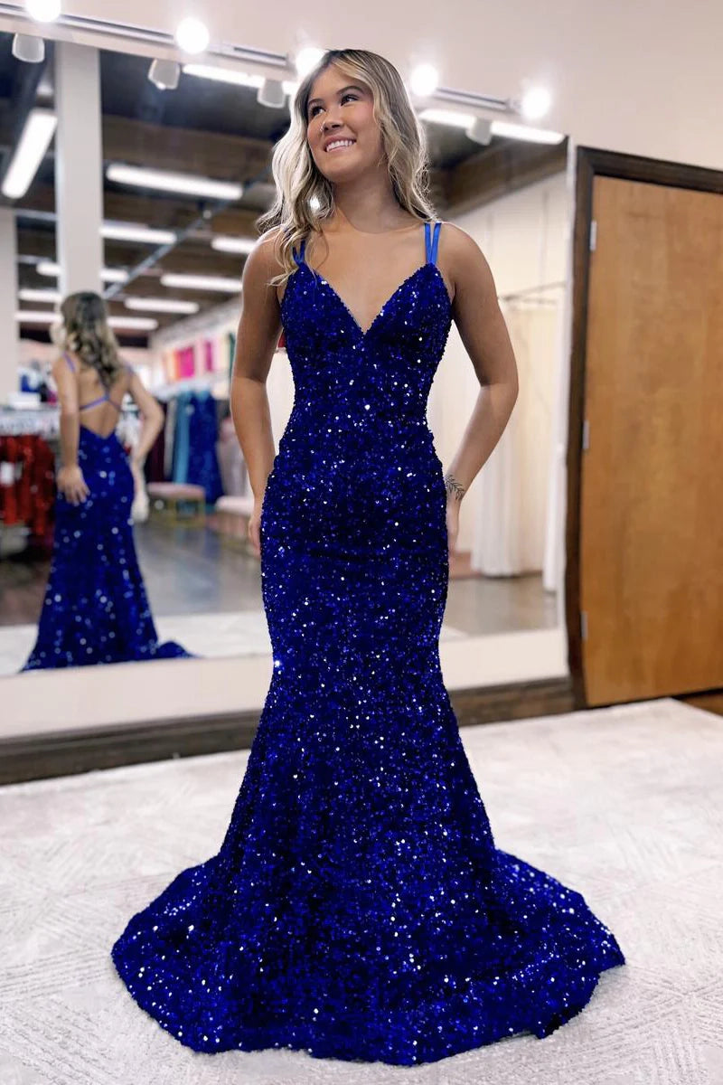 Woman wearing a dazzling sequined V-neck mermaid prom dress with a backless design and sweep train.